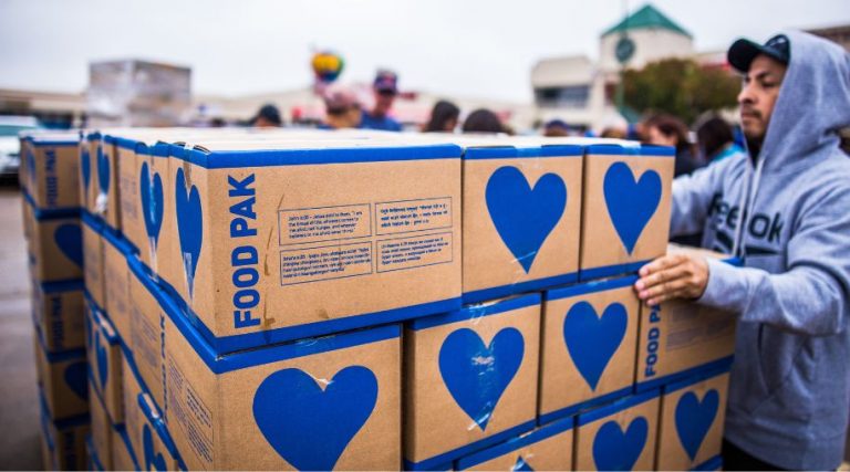 A man sorting boxes of food bank donations.